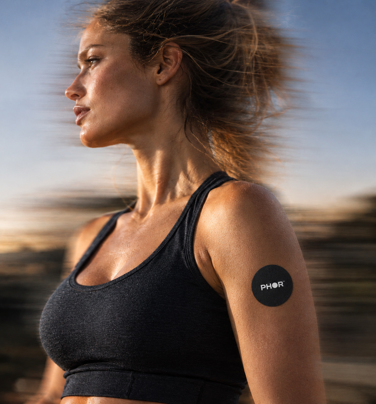 Wind-swept athlete wearing the PHOR patch on her upper arm